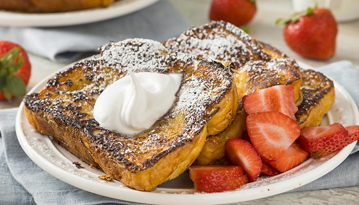 French toast topped with whipped cream, powdered sugar and strawberries breakfast menu at Wheaton Family Restaurant in Eau Claire, WI